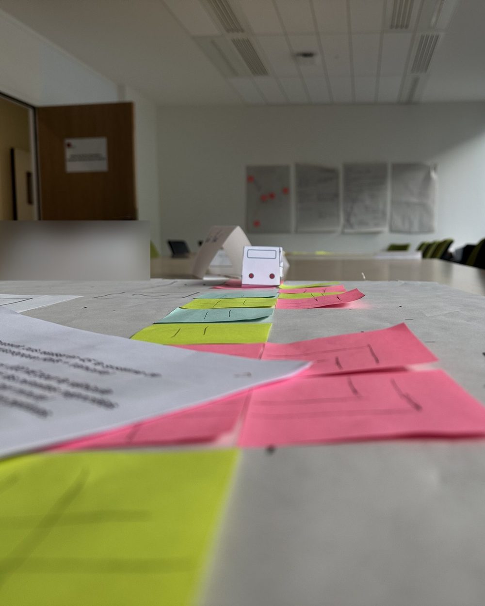 Chemin de post-it et bus en papier sur une table d’atelier
