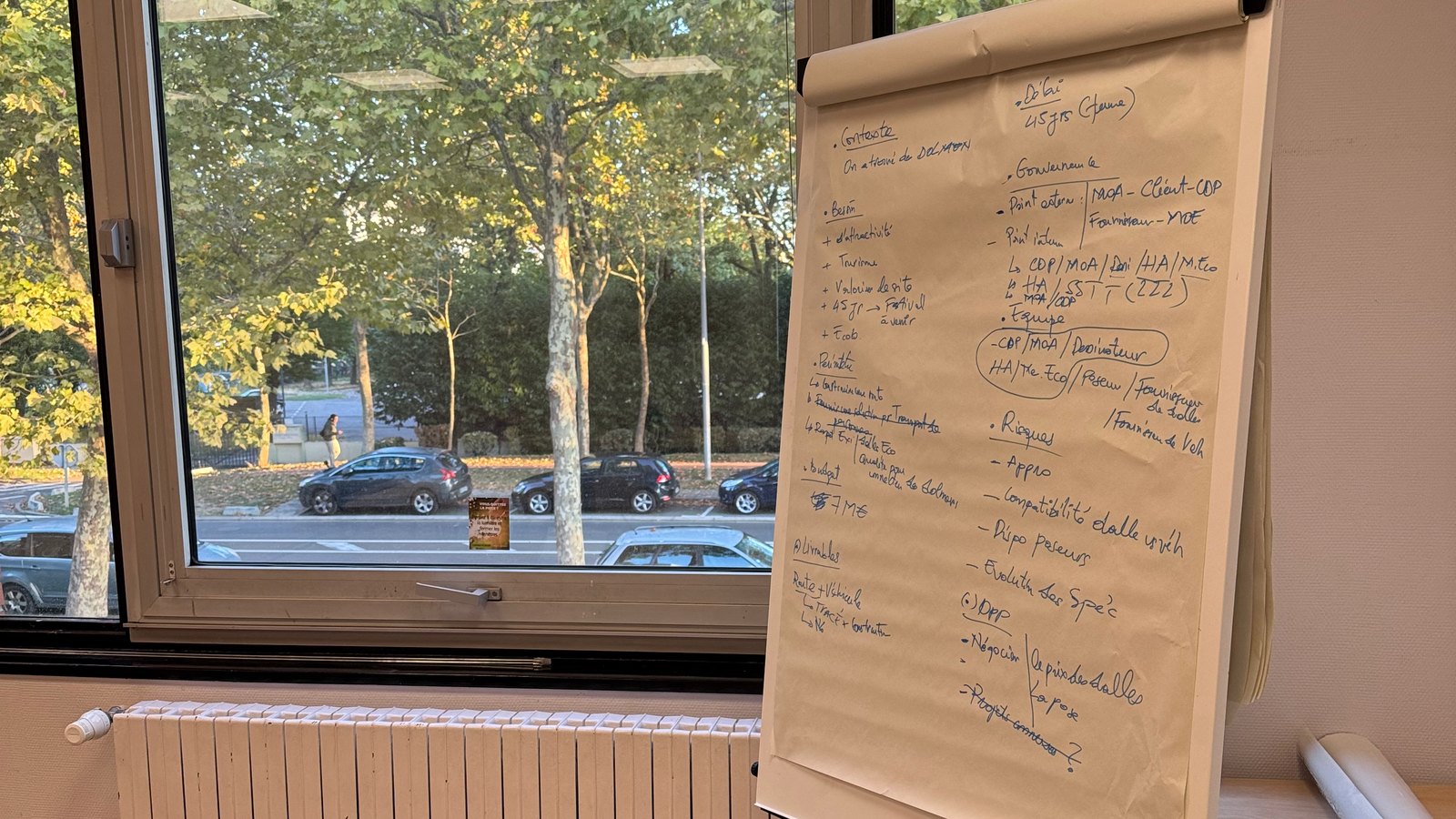 Paperboard en salle de formation avec un cadrage de projet écrit à la main : contexte, besoin, objectifs, gouvernance, risques, budget